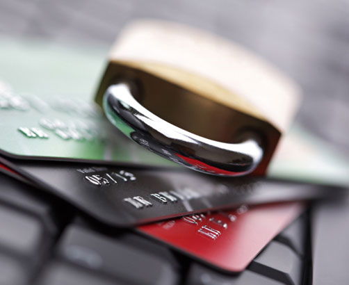 Kilka kart kredytowych oraz kłódka na klawiaturze